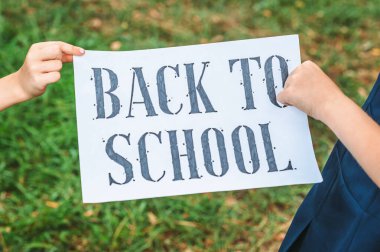 Eski okulun arka planında çocukların elinde, Okula Dönüş yazıtlı tablet