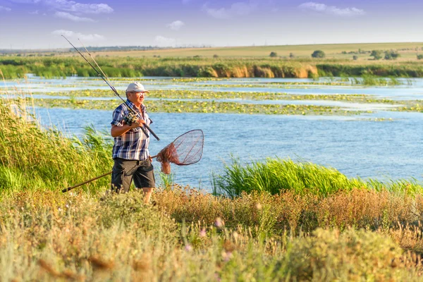 Un pescatore vicino al fiume in una bella giornata di sole — Foto Stock