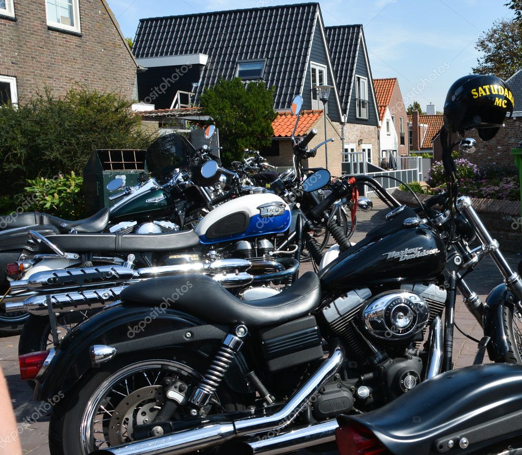 Parked motors on one of the handlebars of the motorcycle, a helmet with the yellow letters 