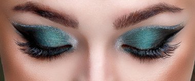 Güzel makyajlı genç bir kızın yakın görüntüsü.