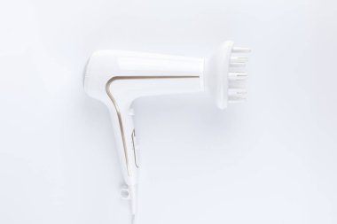 Beyaz arkaplanda dağınık stil eklentisi olan saç kurutma makinesi