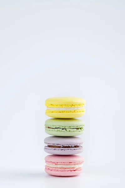 Beyaz arkaplanda renkli badem kurabiyeleri yığını