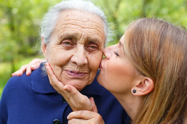 Młoda kobieta całując jej piękny babcia — Zdjęcie stockowe