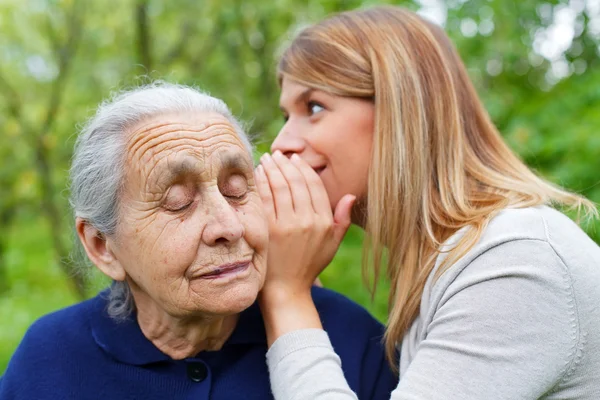 Susurrando un secreto a la oreja de la abuela — Foto de Stock