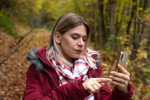 Piękna Młoda Kobieta Tworząc Treści Online Smartfonem Kolorowe Jesienne Tło — Zdjęcie stockowe