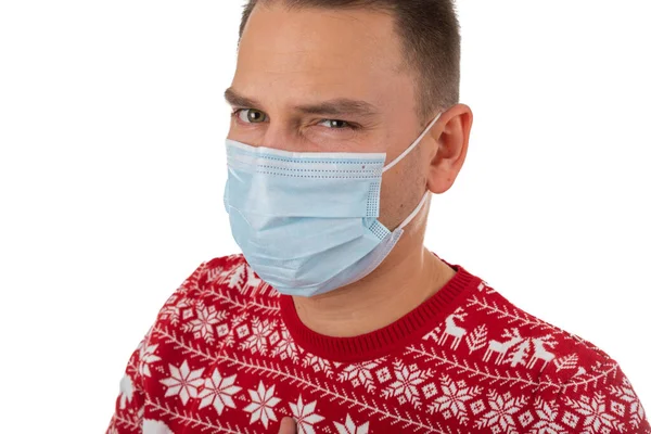 크리스마스 스타일의 뜨개질 남자의 초상화가 배경에서 외과용 마스크를 — 스톡 사진