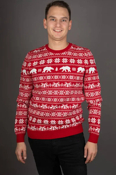 Junger Mann Mit Gestricktem Weihnachtspullover Posiert Auf Grauem Hintergrund — Stockfoto