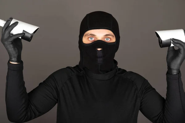 黒い顔のマスクをした泥棒の写真は 監視カメラをオフにしようとしています — ストック写真