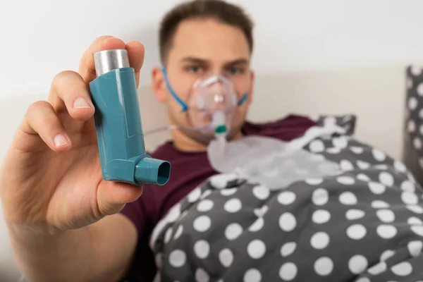 Férfi Beteg Oxigénmaszkkal Otthon Fekszik Ágyban Kezében Egy Inhalátor Spray — Stock Fotó