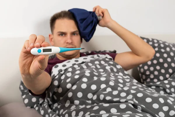 Sick Young Caucasian Man Lying Bed Home Holding Digital Thermometer — Stock Photo, Image
