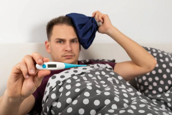 Sick Young Caucasian Man Lying Bed Home Holding Digital Thermometer — Stock Photo, Image