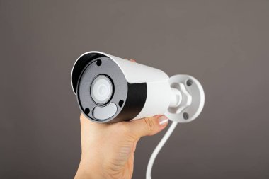 Gri arka planda insan eliyle çekilmiş güvenlik kamerası görüntülerini kapat