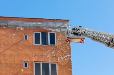 Bir inşaat sahasının resmi, gökyüzüne karşı gelişmekte olan modern düz bina.