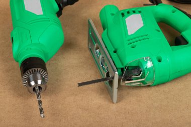 Yeşil bir testereyle ahşap bir arka planda matkap resmi.