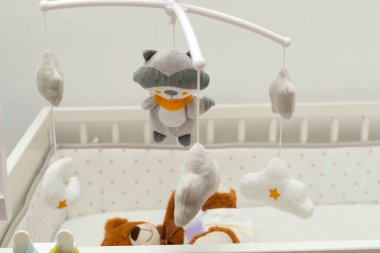 Bebek yatağında bebek bezi takmış kahverengi bir ayı heykeli.