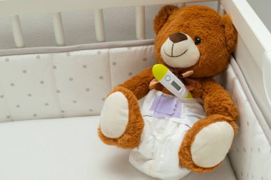 Bebek yatağında bezi olan kahverengi ayıcık.