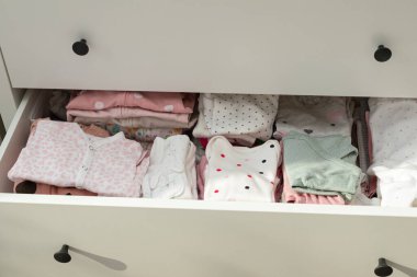 Çekmeceye yerleştirilmiş şirin bebek kıyafetleri.