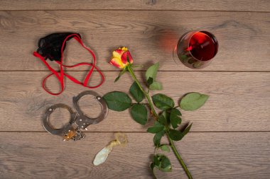 İç çamaşırı, kelepçe, tahta zeminde gül, sevgililer günü konsepti.