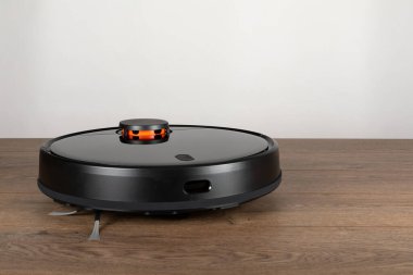 Yerde paspasla otomatik akıllı bir robot süpürge resmi.