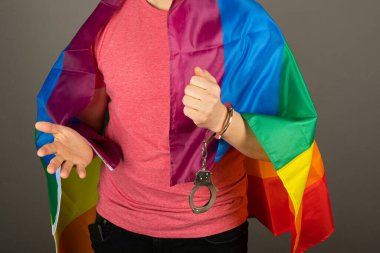 Pembe tişört ve gökkuşağı bayrağı giymiş eşcinsel bir adam.