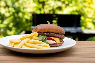 Ev yapımı lezzetli çizburger arka bahçede mangalda pişiriliyor.