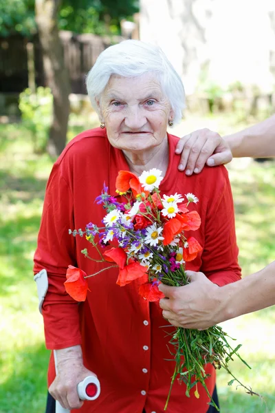 Vecchia donna con un bouquet — Foto Stock