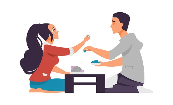 Menino e menina dos desenhos animados no encontro. Um casal feliz no café. As pessoas dão comida para experimentar. Cena romântica. Namorado e namorada sentar-se à mesa e comer refeição. Os amantes de vetor descansam juntos no restaurante —  Vetores de Stock