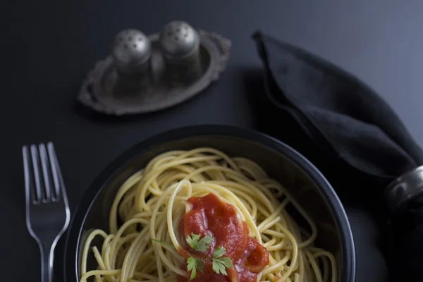 Spaghetti al dente in a black bowl — Stock Photo, Image