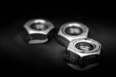 Close up of set of rusty screw-nuts on a black background with copy space