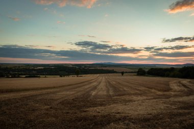 Macaristan kırsalındaki çayırların üzerinde kasvetli bir gün batımı