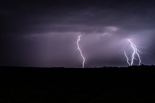 Multiple lightning strikes lighting up the sky on a summer evening during a thunderstorm