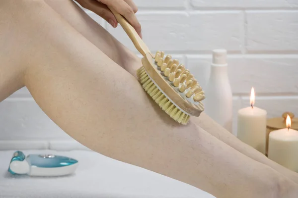 Exfoliation with a natural bristle brush. Dry brush massage. Preparing the skin for epilation. Strawberry legs, keratosis. Home skin and body care. SPA. Hairy legs. Beautiful slim female legs.