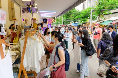 Bangkok, Tayland - 22 Ağustos 2020: Kimliği belirsiz kişiler cerrahi maske takıyor ve Chatuchak pazarında yeni elbise seçiyorlar