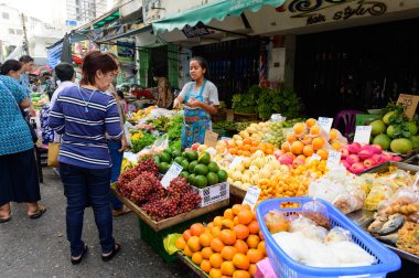 Bangkok, Tayland - 22 Ekim 2020: Silom 20 'deki sokak pazarında kimliği belirsiz kadın meyve satışı