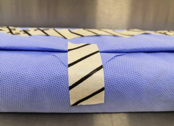 Wrapped Surgical Instrument Pack. Pack With Drape Sheet And Indicator Tape. Selective Focus