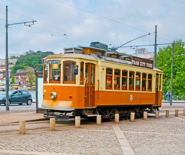 PORTO, PORTUGAL - 30 Nisan 2012: Klasik tramvay 30 Nisan 'da Porto' da, arka planda Douro Nehri seti olan istasyonda turistleri bekliyor.