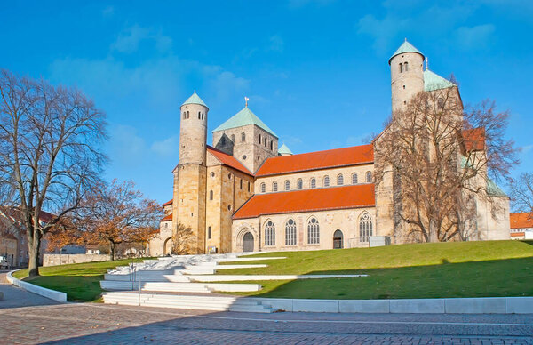The tall stone towers and huge Romanesque building of Hildesheim Cathedral (Dom), located in Domhof square, Germany
