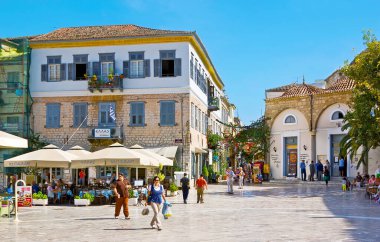 NAFPLIO, GREECE - 11 Ekim 2013: Nafplio 'da Vasileos Konstantinou caddesinde yer alan Eski Cami (Trianon) çevresindeki açık hava restoranları ve kasabacı dükkanları