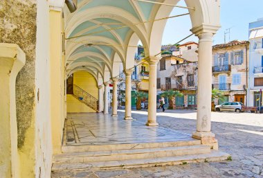 Aziz George kilisesinin dış cephesi korunmuş sütunlu ve Plapouta caddesi manzaralı eski konutlu, Nafplio, Yunanistan