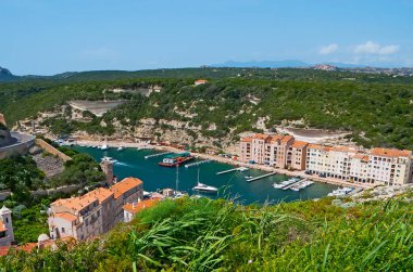 Bonifacio limanının en üst manzarası tersanelerdeki yatlar ve aşağı kasabadaki binalar, kireçtaşı uçurumları ve deniz kıyıları boyunca uzanan, Corsica, Fransa