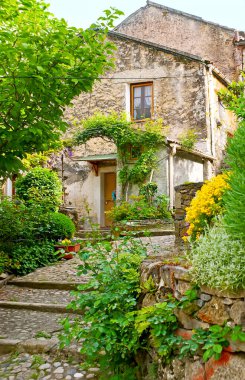Eski Corte 'nin dolambaçlı sokaklarını keşfedin. Küçük bahçeleri, çiçekli yatakları, eski taş evleri ve gizli bahçeleri, Korsika, Fransa