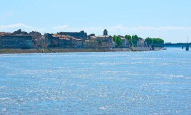 Ön planda Rhone Nehri olan eski Arles manzarasının tadını çıkarın, Fransa