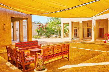 Tenteli, bankları ve kerpiç evleri olan gölgeli avlu, Al Shindagha Mahallesi, Dubai, BAE