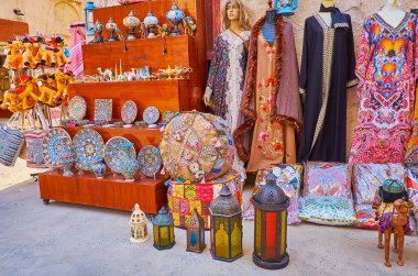 Al Fahidi market, Dubai, BAE 'nin caddesinde bulunan turist dükkanının farklı malları (giysi, çömlek, lamba, yastık, oyuncak)