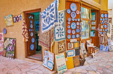Hediyelik eşya dükkanında etkileyici İran el sanatları sunuluyor - Dubai, BAE 'de blok baskılı pamuk ghalamkar halıları ve turuoise minakari çömlekleri, Al Souk al Kabir (Eski Pazar)