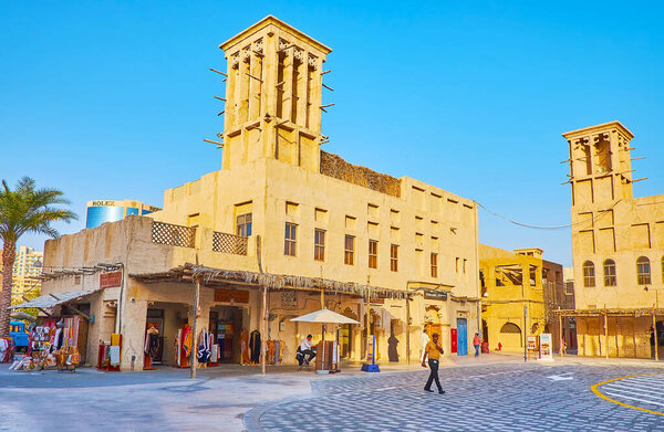 ДУБАЙ, ОАЭ - 8 МАРТА 2020: 8 марта в Дубае на первых этажах традиционных адобе-зданий Аль-Фахиди расположены туристические магазины, рестораны и кофейни