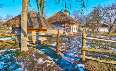 Eriyen karlı bataklık patikası tarihi bir çiftliğe götürür. Kereste oyun parkı ve hata evi, Pyrohiv Skansen, Kyiv, Ukrayna