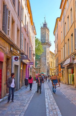 AIX-EN-PROVENCE, FRANCE- 6 Mayıs 2013: Kalabalık Paul Bert Caddesi, birçok mağaza, kafe ve saat kulesi manzaralı, 6 Mayıs 'ta Aix-en-Provence