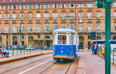 TURIN, ITALY - 9 Mayıs 2012: Mavi vintage tramvay 9 Mayıs 'ta Torino şehrinin arka planında, Piazza Castello boyunca uzanan tuğla bir binayla birlikte Torino' da görülüyor.