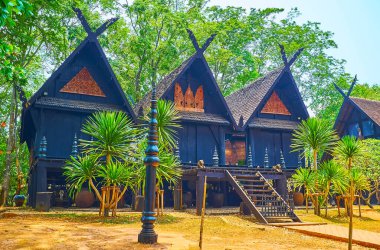 CHIANG RAI, THAILAND - 11 Mayıs 2019: On İki Galae Üçüzü Kara Ev, 11 Mayıs 'ta Chiang Rai' deki Baan Dam (Kara Ev) kompleksi, Lanna tarzı oymalarla süslenmiş üç küçük tahta binadan oluşuyor.